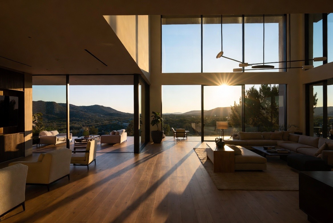 Open plan living room with floor-to-ceiling windows and Hill Country sunset views