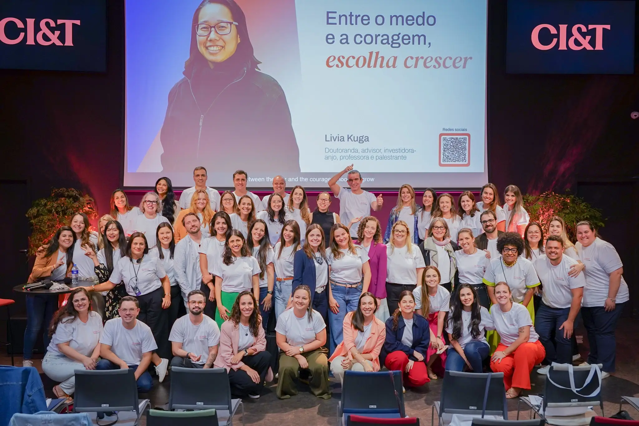 Grupo de pessoas em cima do palco após palestra 