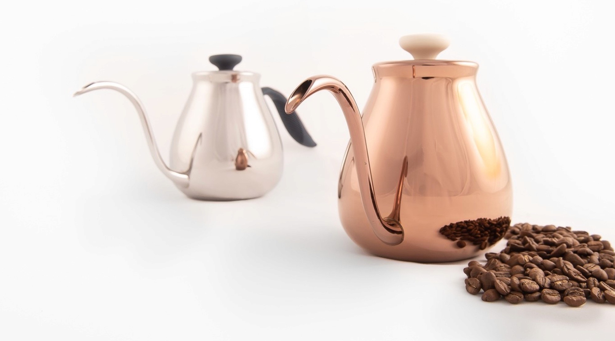 這張圖像展示了PAUS的手沖咖啡壺產品照片,包括一個銅色和一個銀色的手沖壺,旁邊有一堆咖啡豆。