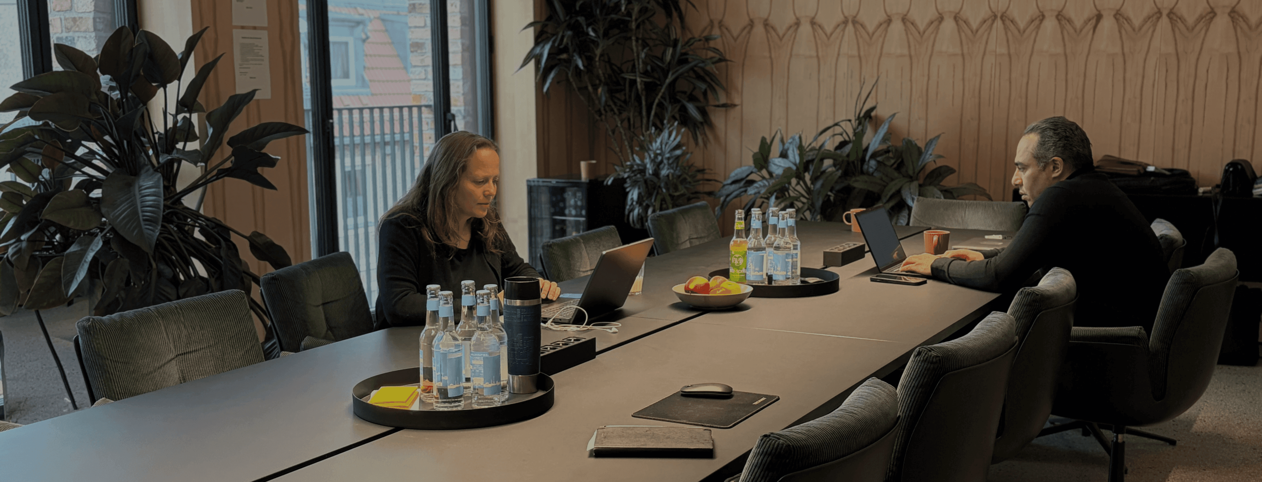 people sitting on chair in front of table while holding pens during daytime