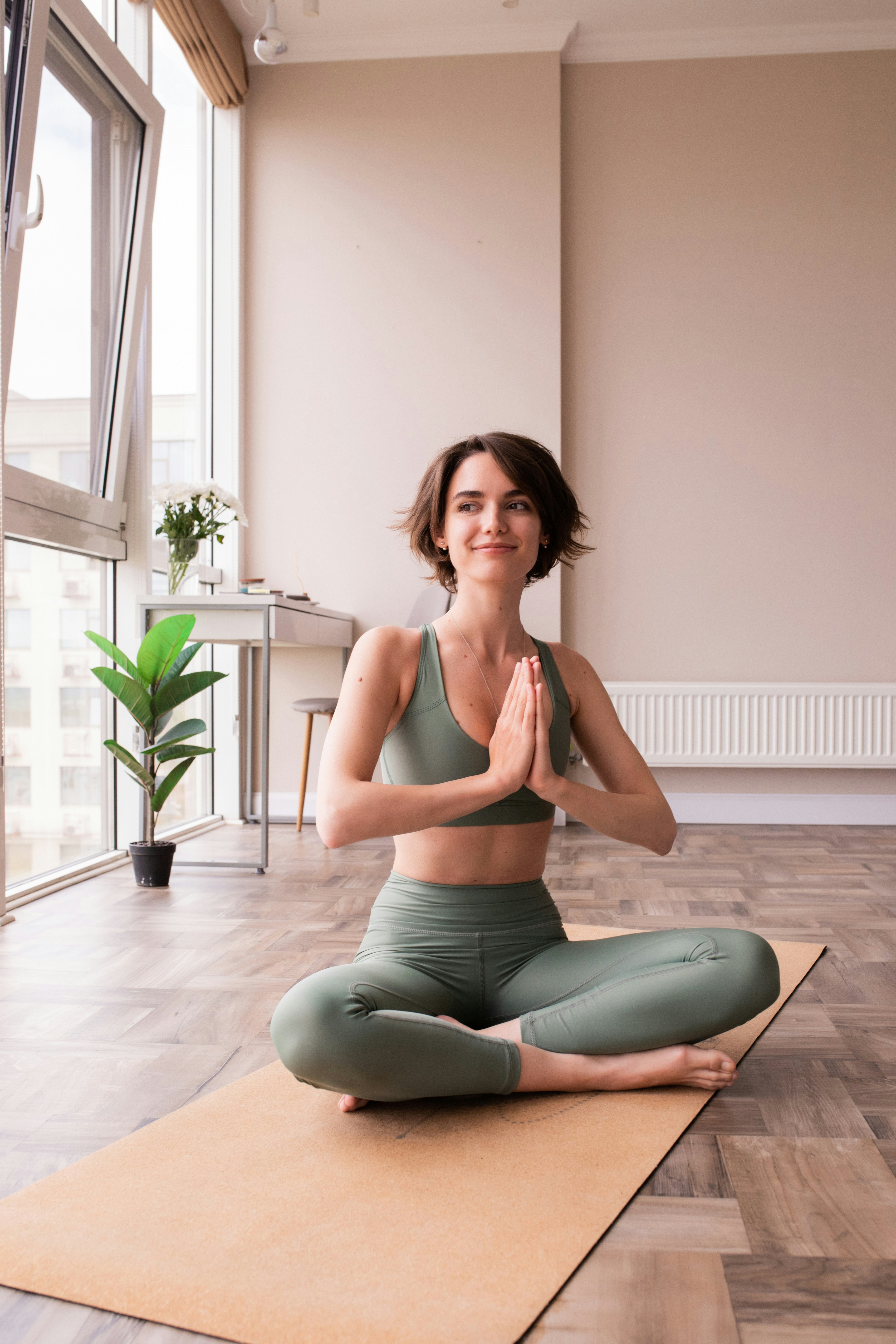 Femme assise sur un tapis de yoga dans une salle