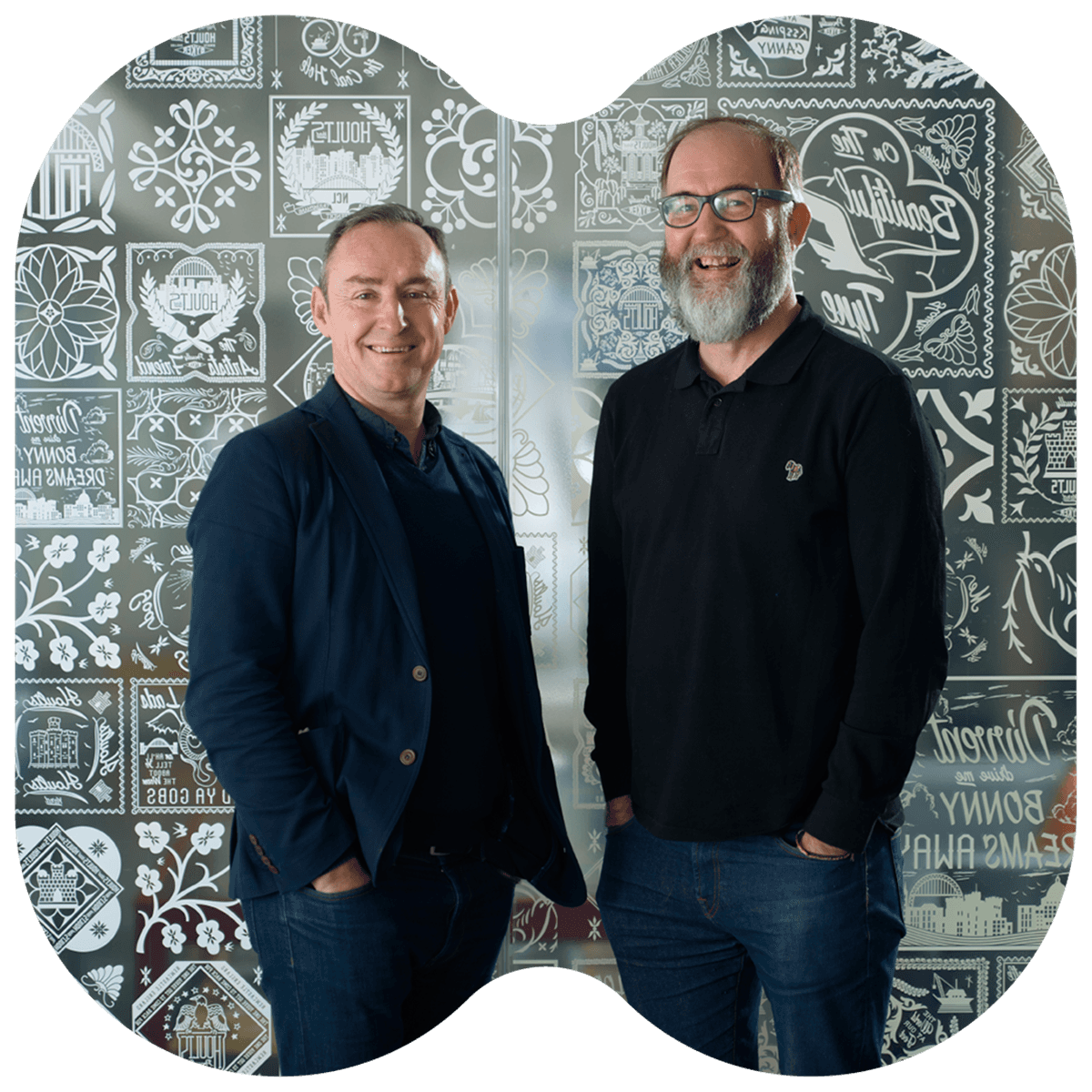 Photo of the Opencast founders smiling for the photo in front of a grey patterned backdrop
