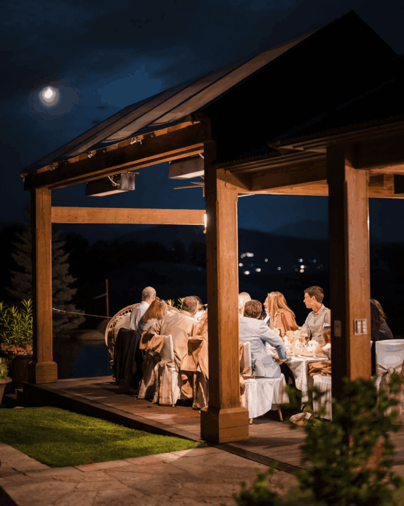 Wedding guests dining beneath an open pavilion at night