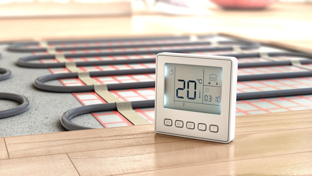 An underfloor heating system, to the left is the exposed pipework and to the right is a thermistat