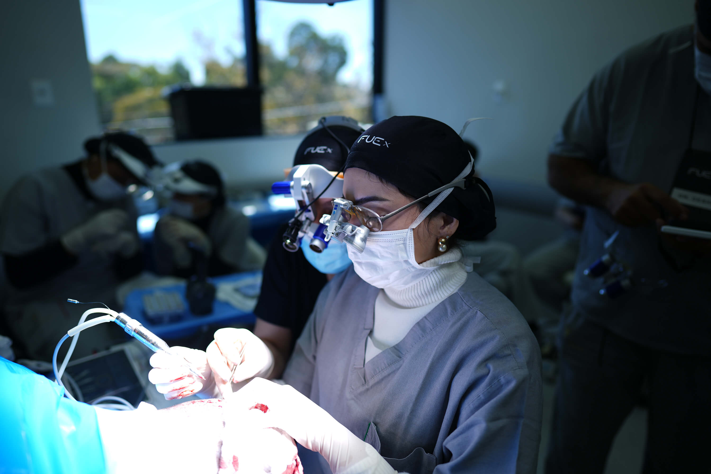 Médicas fazendo um transplante capilar. 