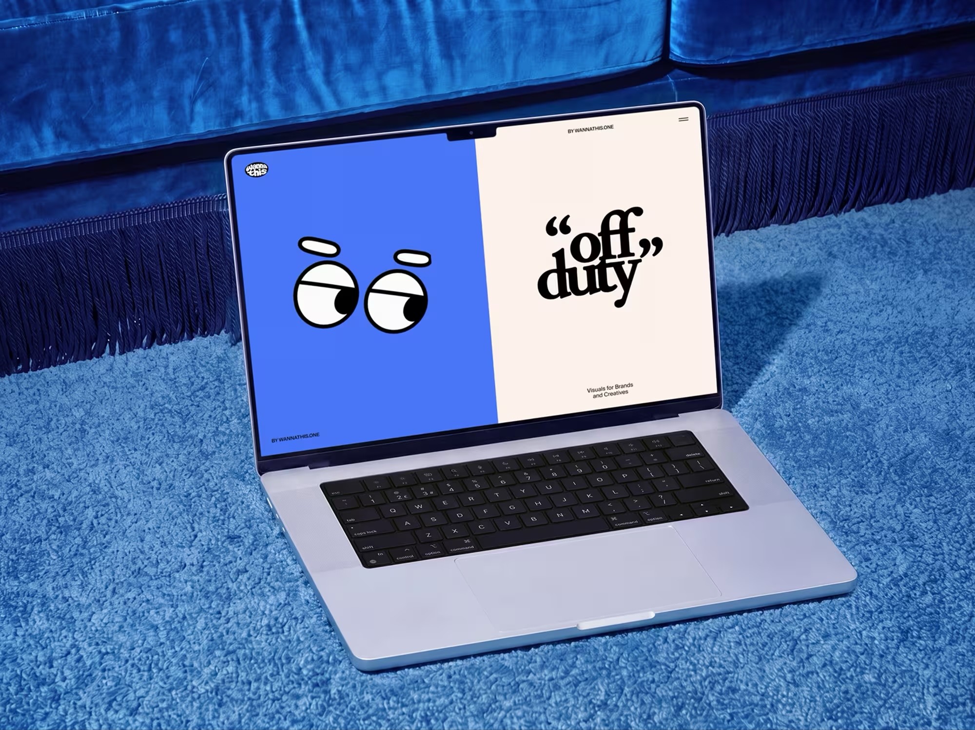 Laptop on a blue rug showing a playful blue and cream website