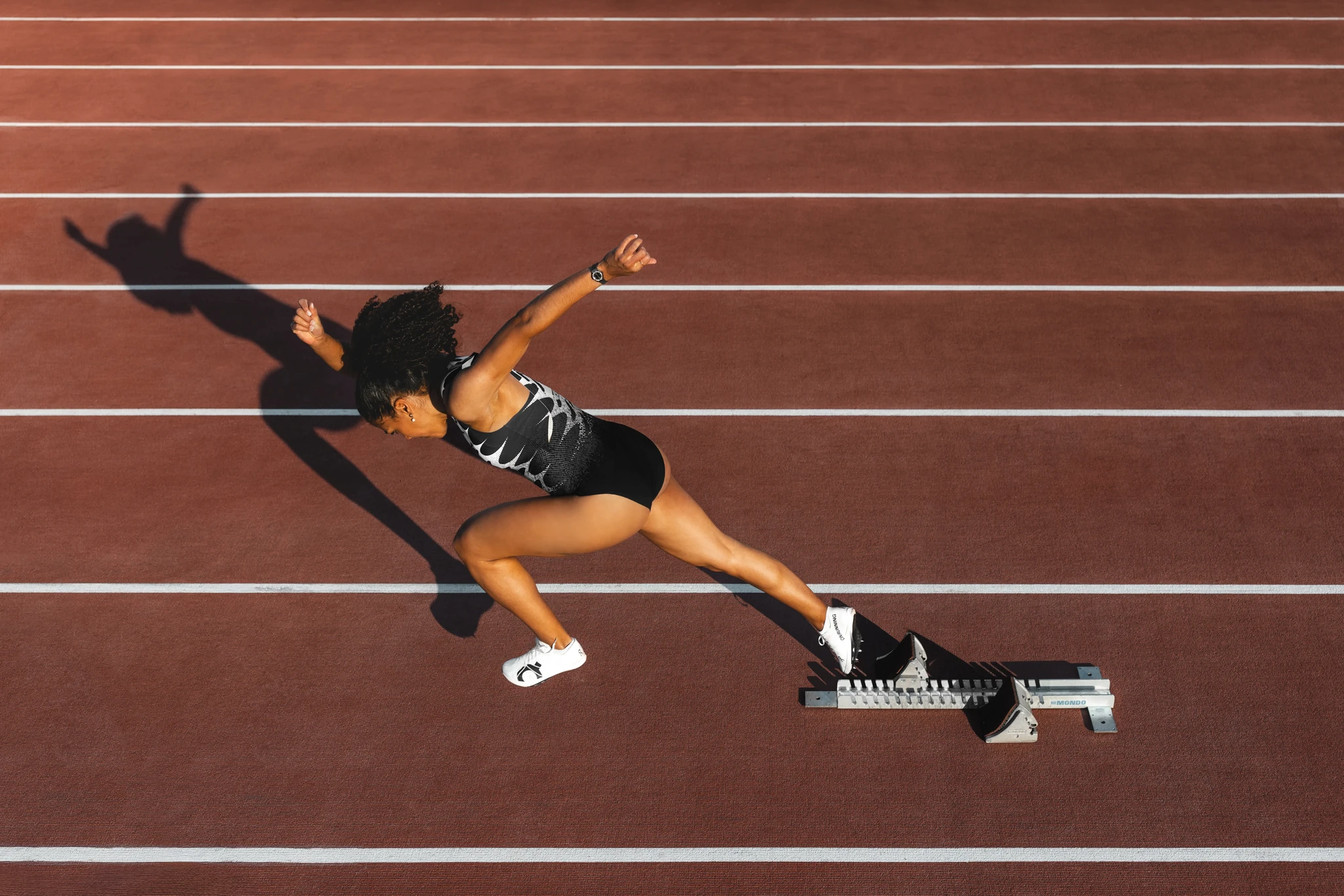 Swiss Olympic sprinter Mujinga Kambundji running on track wearing On AG performance gear. Sports photography by Mathäus Gartner
