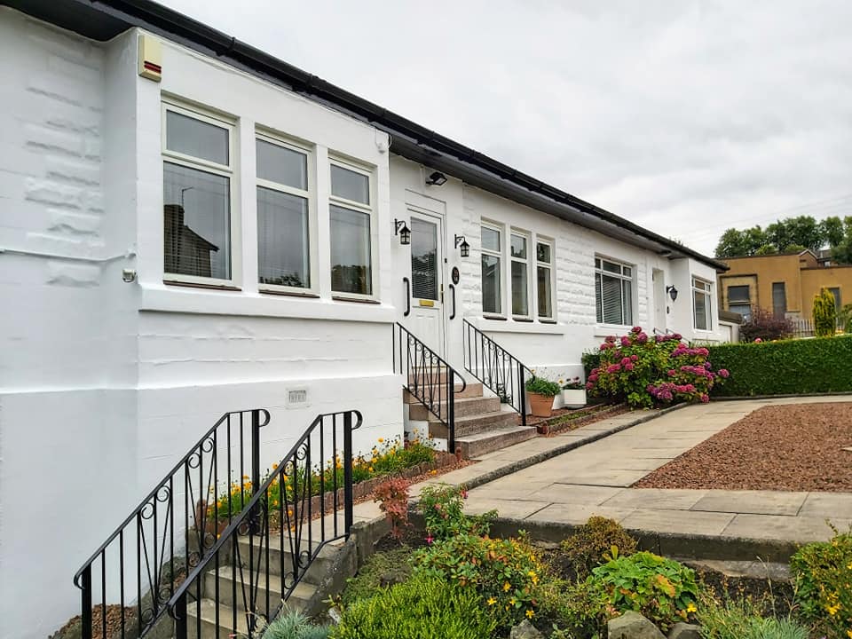 White house exterior with steps leading up to front door
