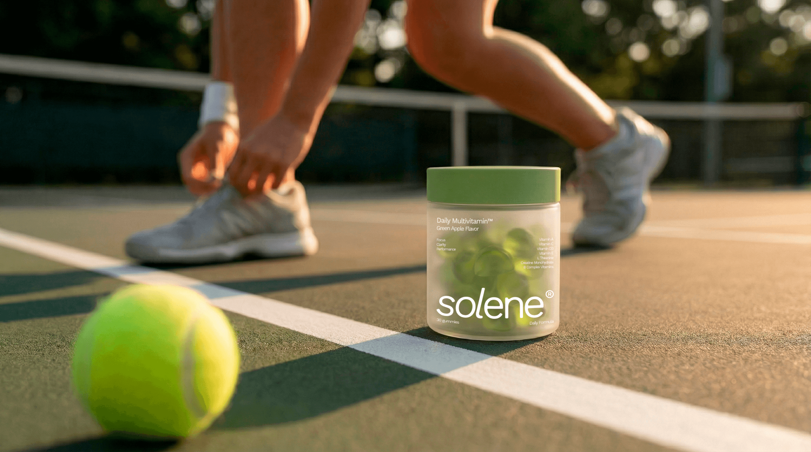 A person tying their tennis shoes to play tennis with the pot in gummy container on the floor.