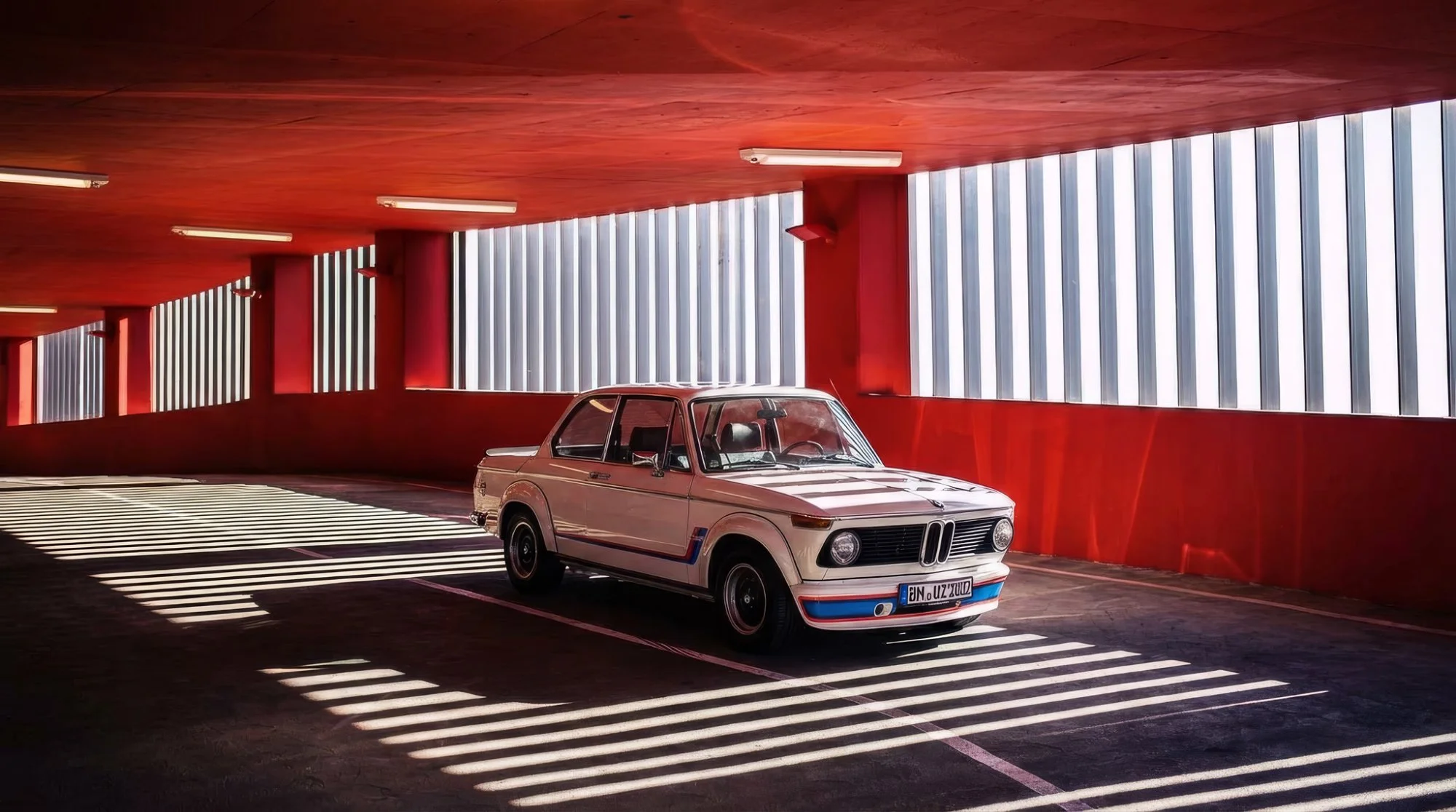 BMW 2002 Turbo Oldtimer in rotem Parkhaus – H-Kennzeichen und Kaskoversicherung für Klassiker