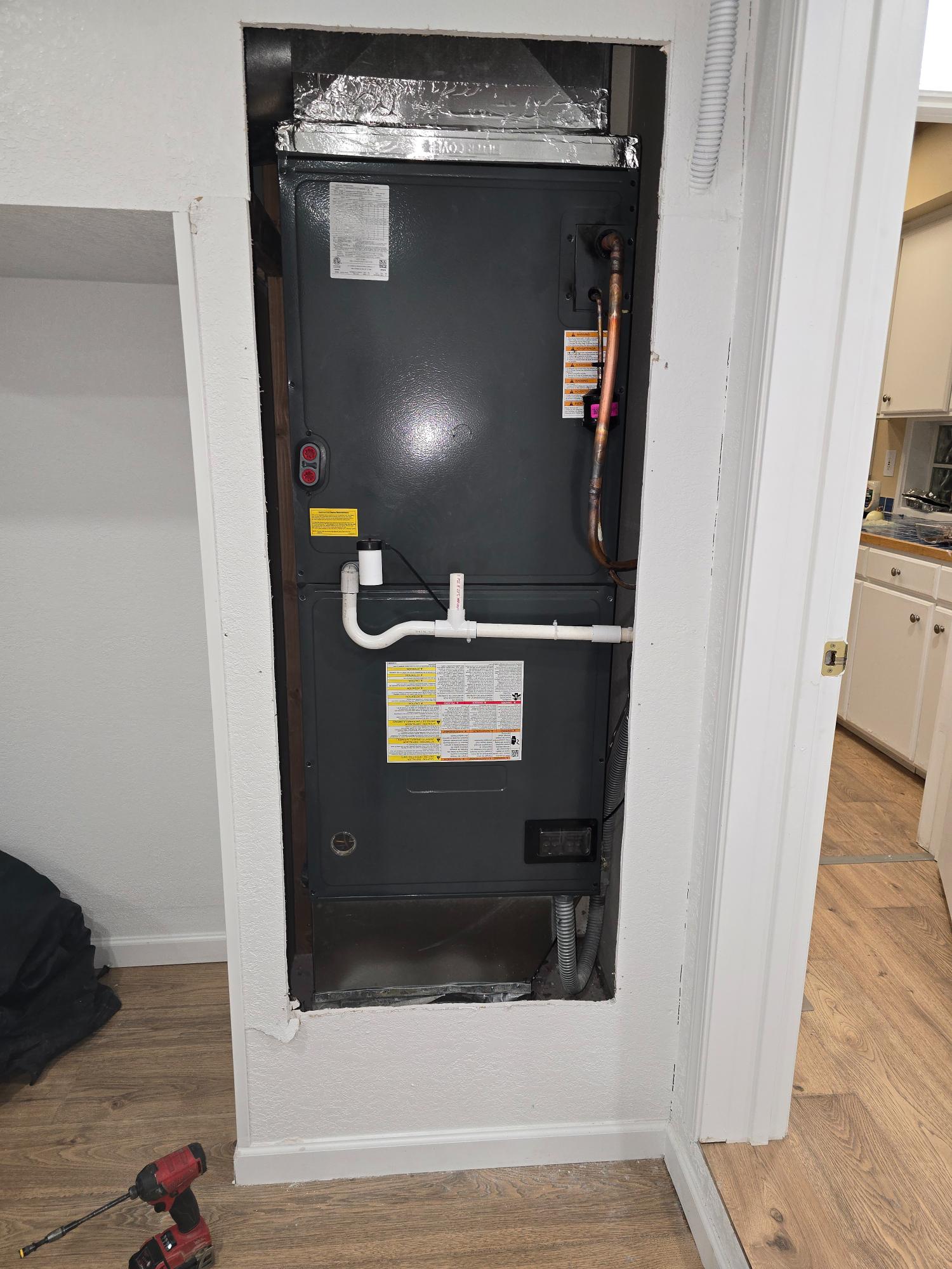 Indoor air handler unit installed in a wall cavity.