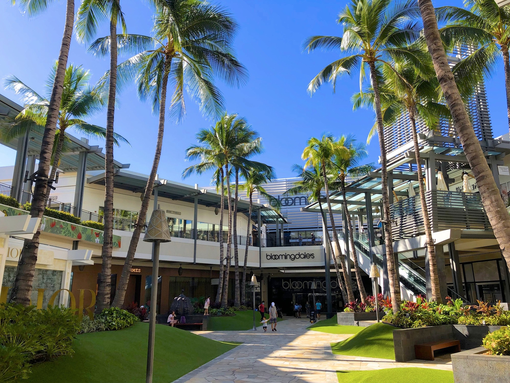 a street lined with stone buildings next to a lush green forest