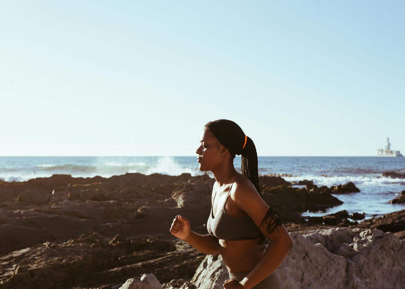 Woman training for a marathon by running along the seaside