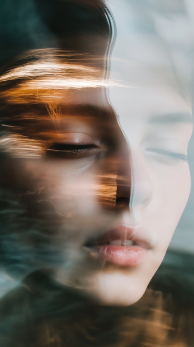 Abstract, blurred close-up of a person's face with light streaks.
