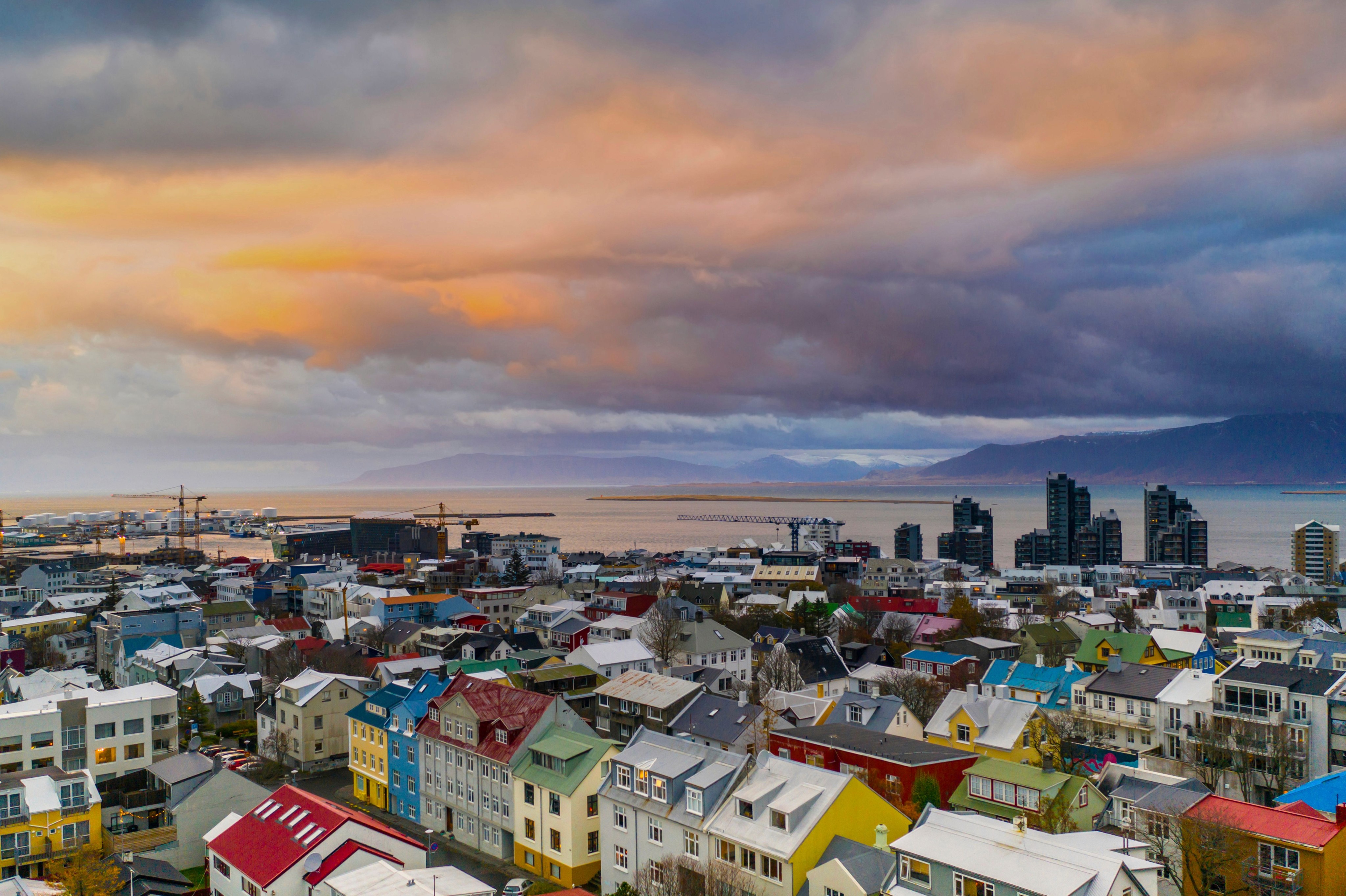 Colourful rooftops of downtown Reykjavík at sunset with the bay and mountains behind