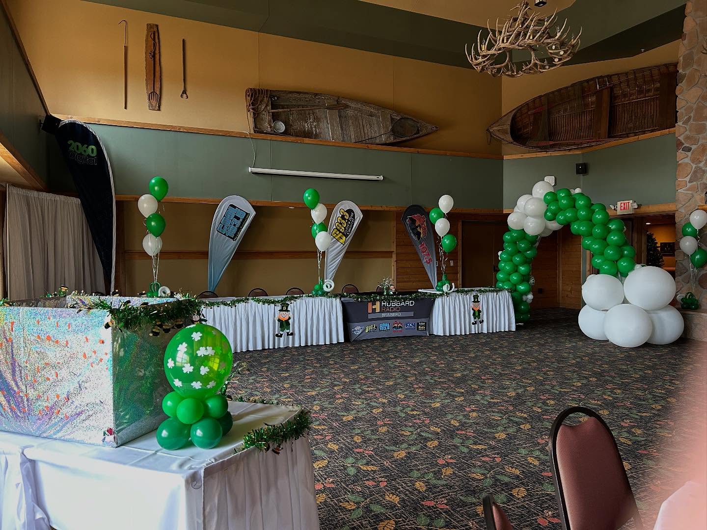Green and white balloon columns  arranged in a lobby for a event by Be Bold Balloons