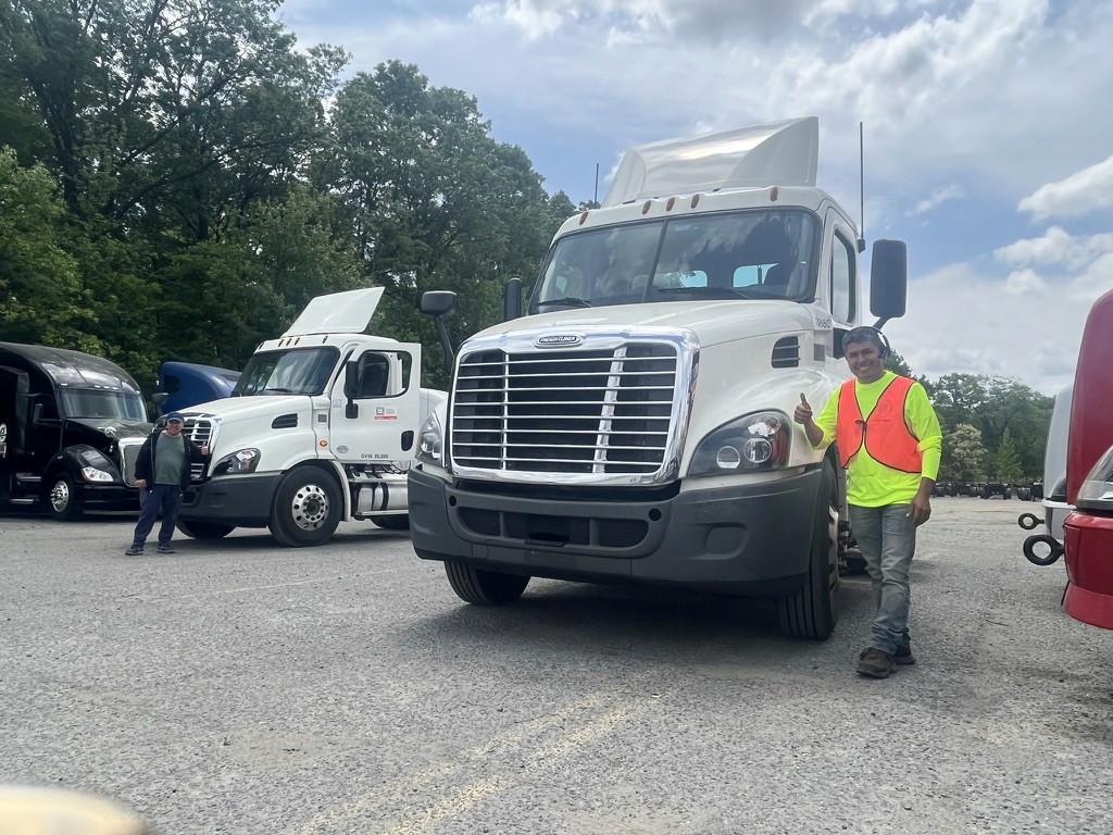 Alpha Cargo team members beside company trucks in the yard