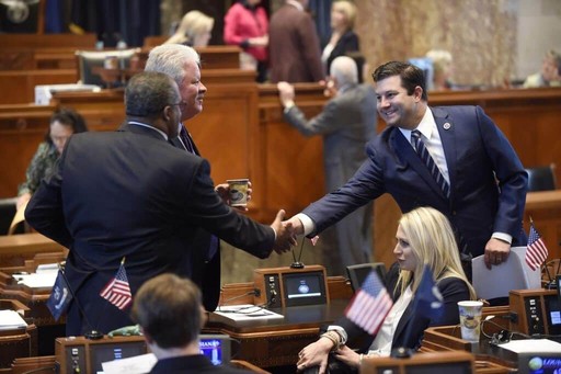 Rick ward smiling and shaking hand with a man in the government