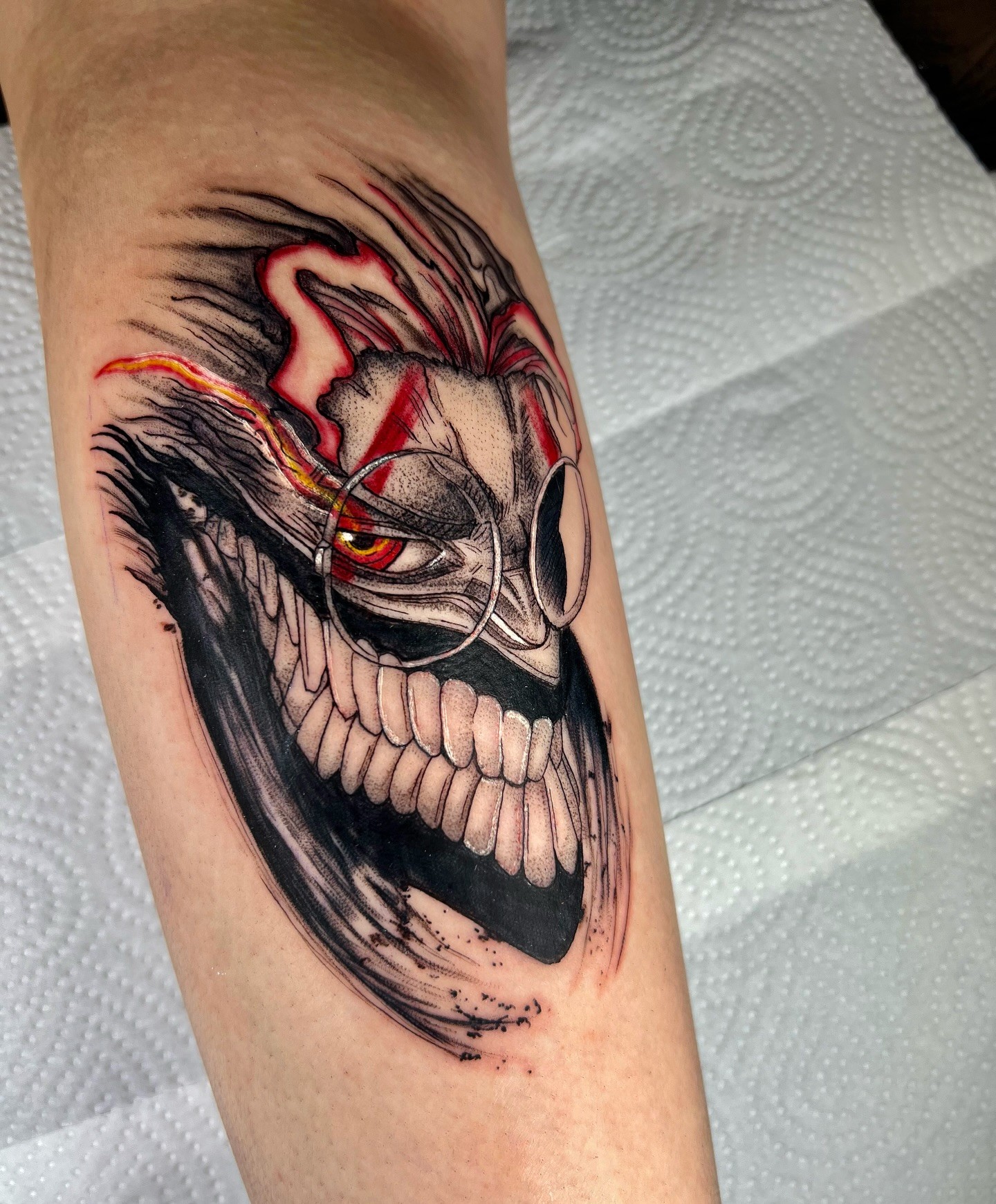 This tattoo of Okarun from Dandadan captures his eccentric energy in a sketchy, dynamic style. The bold black and grey shading is accentuated by fiery red streaks highlighting his transformation, bringing an electrifying vibrancy to the piece. The chaotic line work mirrors the supernatural chaos of the series, making this a perfect tribute for fans of Okarun’s unique journey.