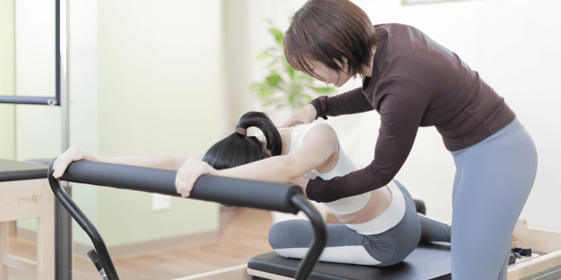 トレーナーに指導してもらってる女性