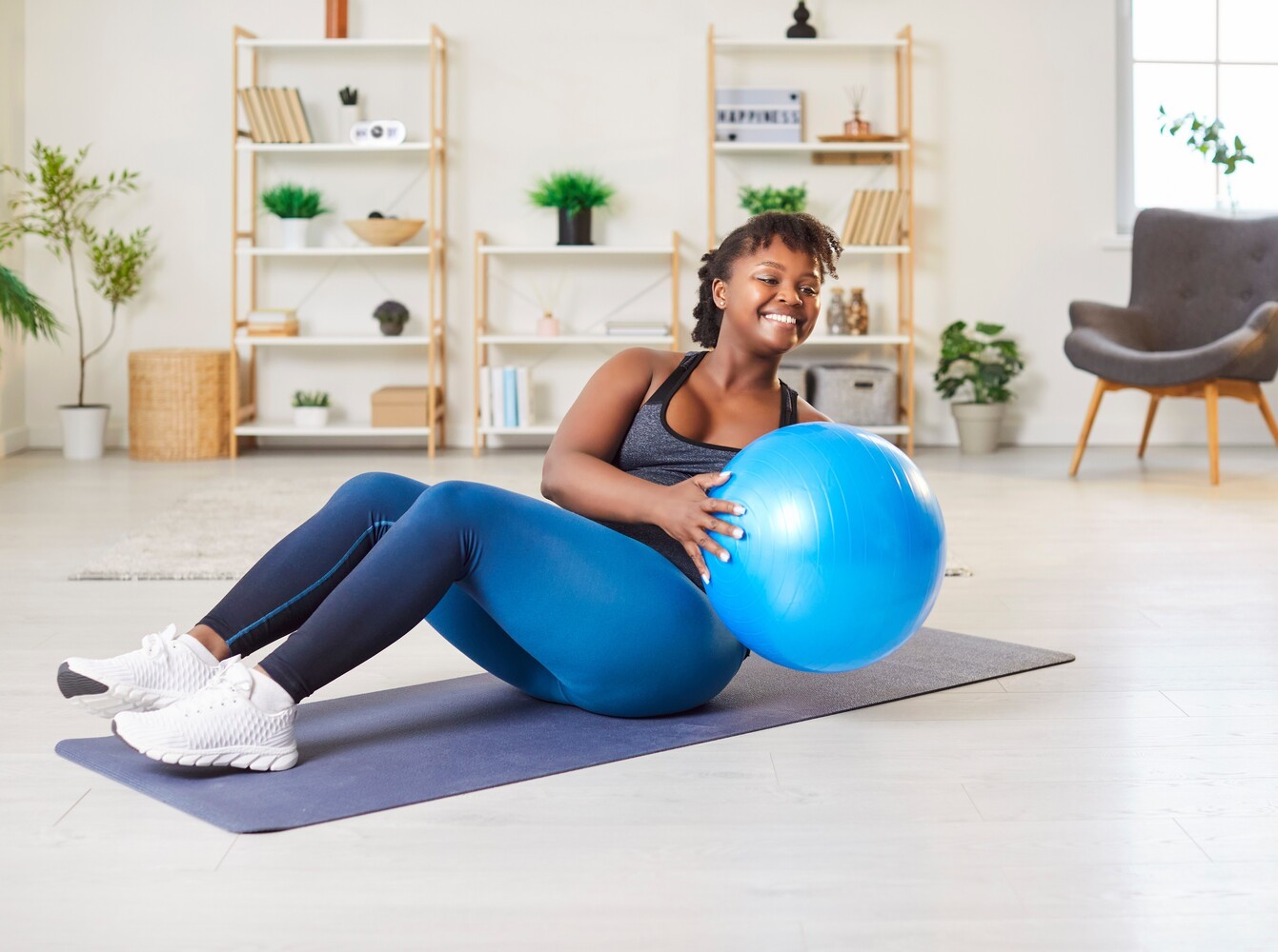 woman increasing the intensity of her workouts for weight loss at home by using an exercise ball