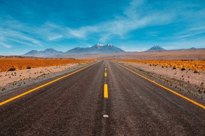 Open desert road leading to distant mountains