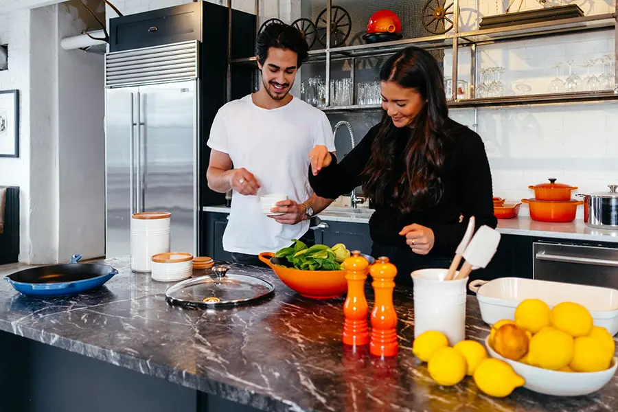 Couple preparing a meal in a bright modern kitchen with spray foam insulated attic
