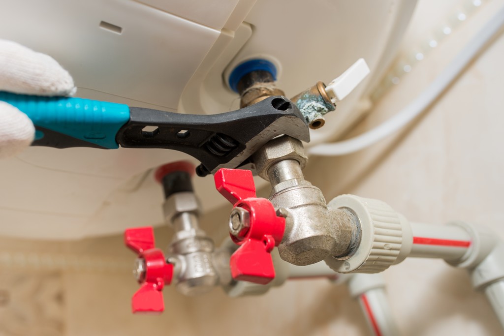 The underside of a boiler, an engineer is removing the boiler