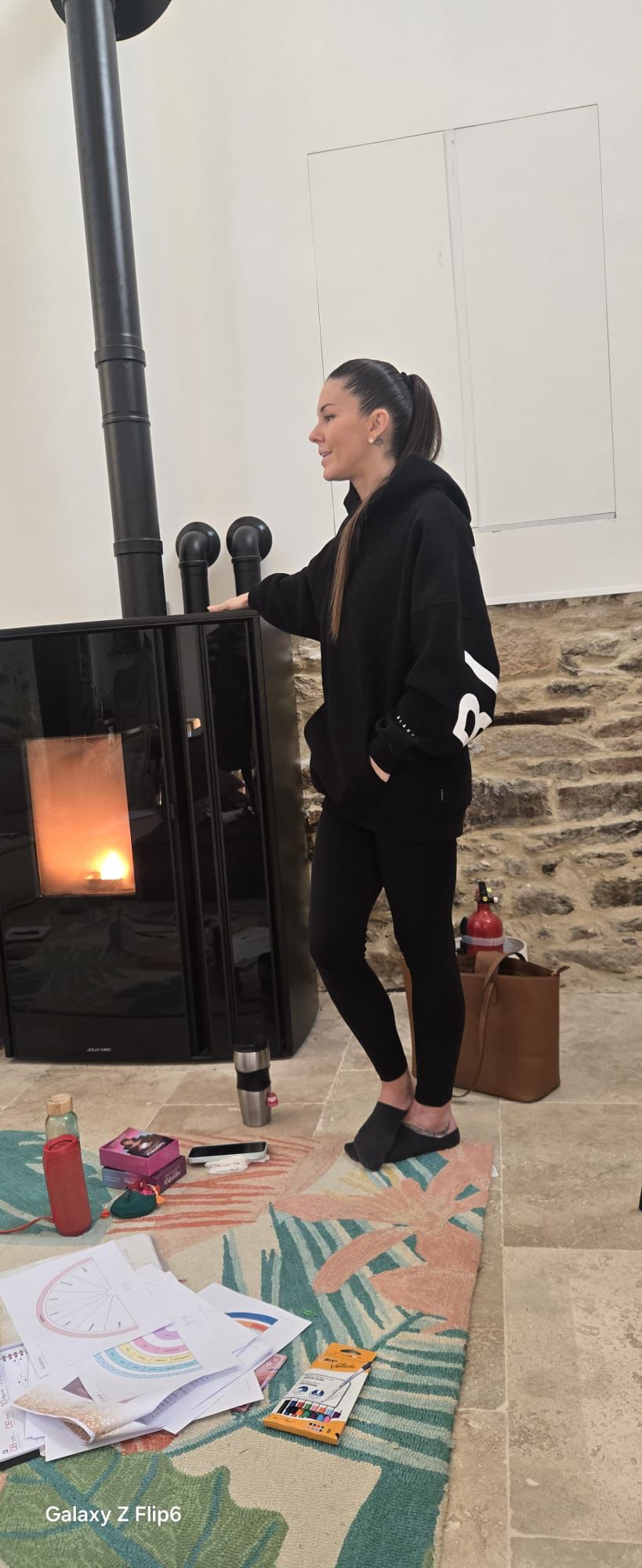 Woman preparing a healthy meal with fresh ingredients and herbal tea in a cozy kitchen filled with natural light.