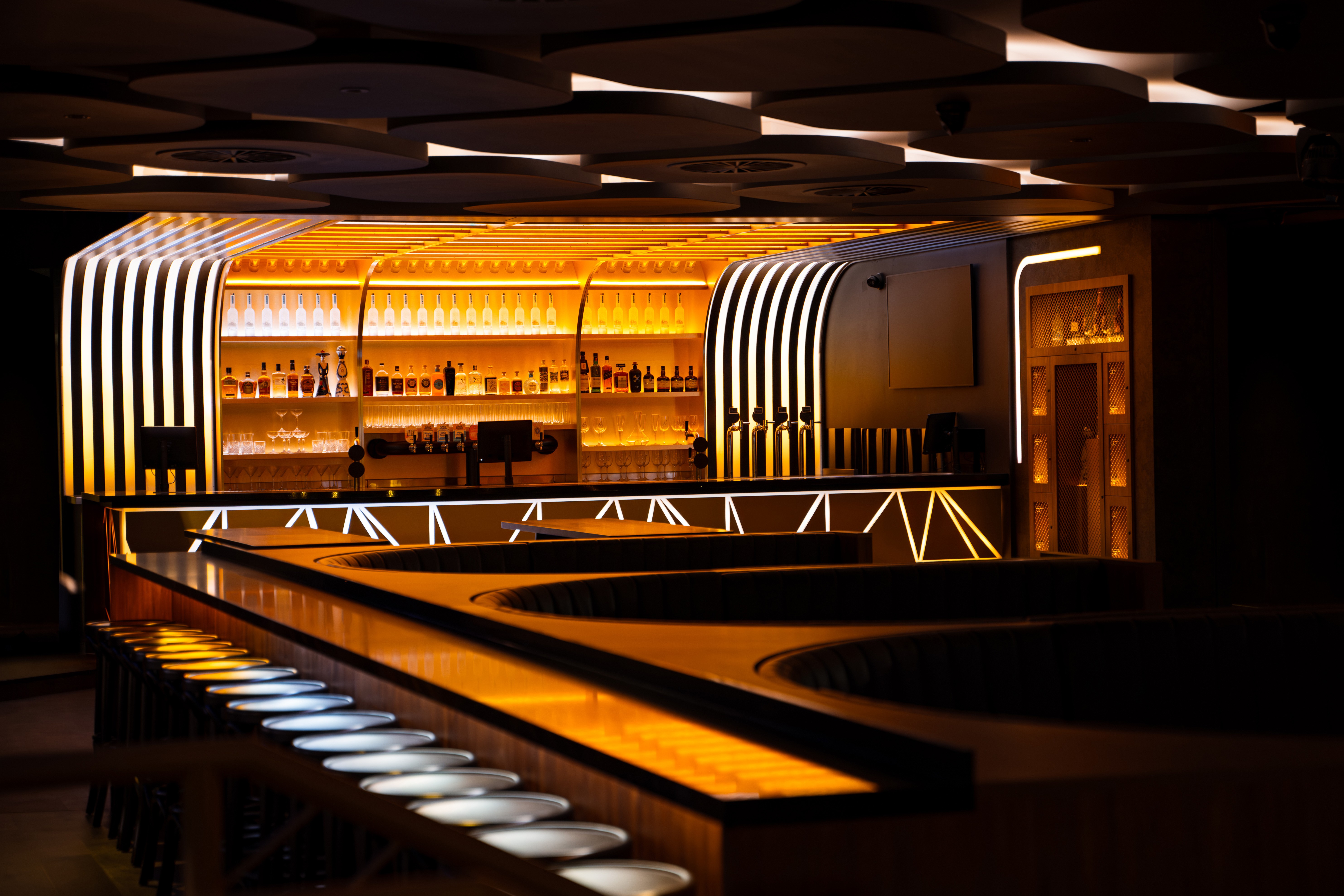 Professional interior photography of Encore Rockingham, showcasing warm geometric lighting and a premium, modern bar design.