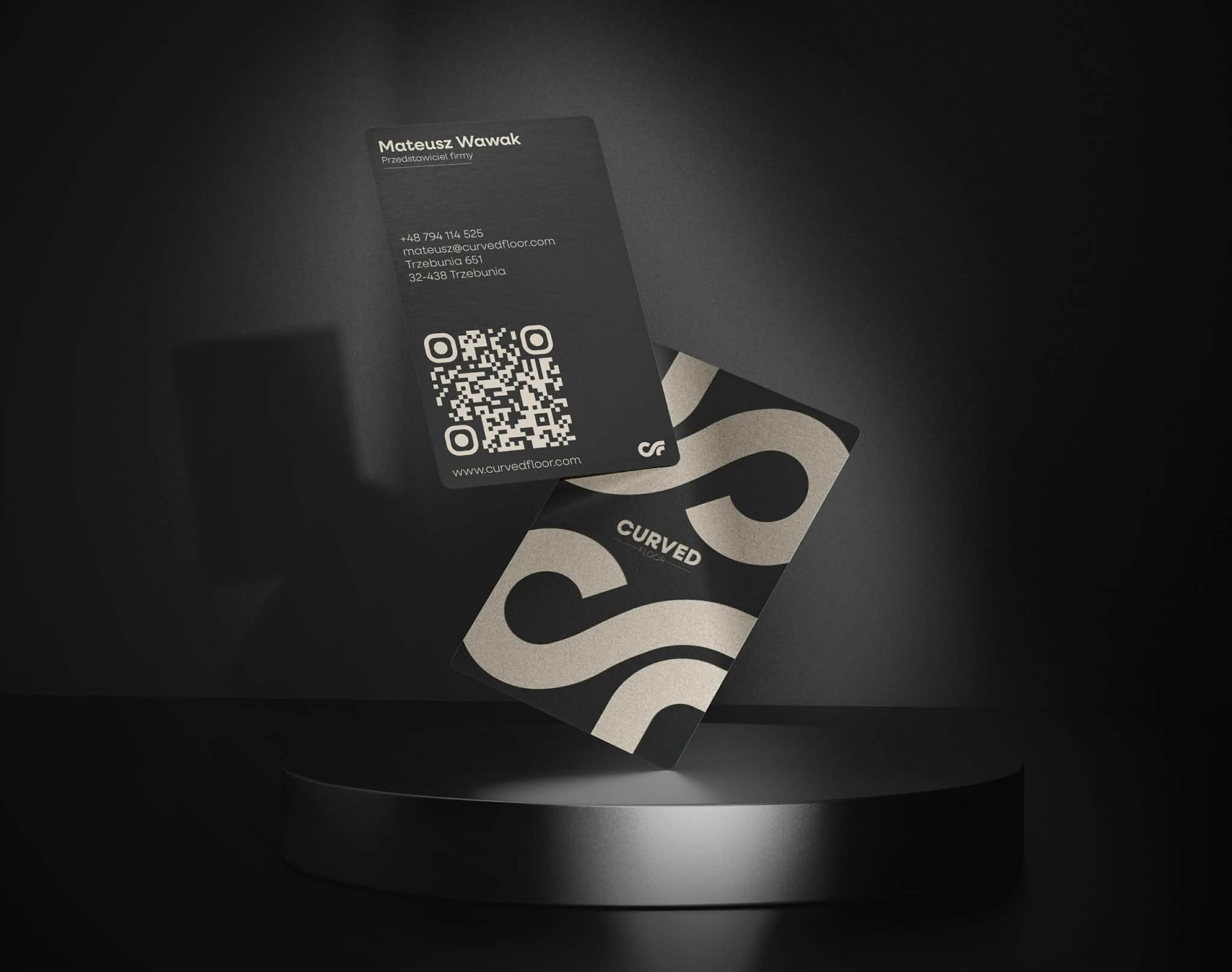 man wearing grey t-shirt standing in front of man sitting on chair