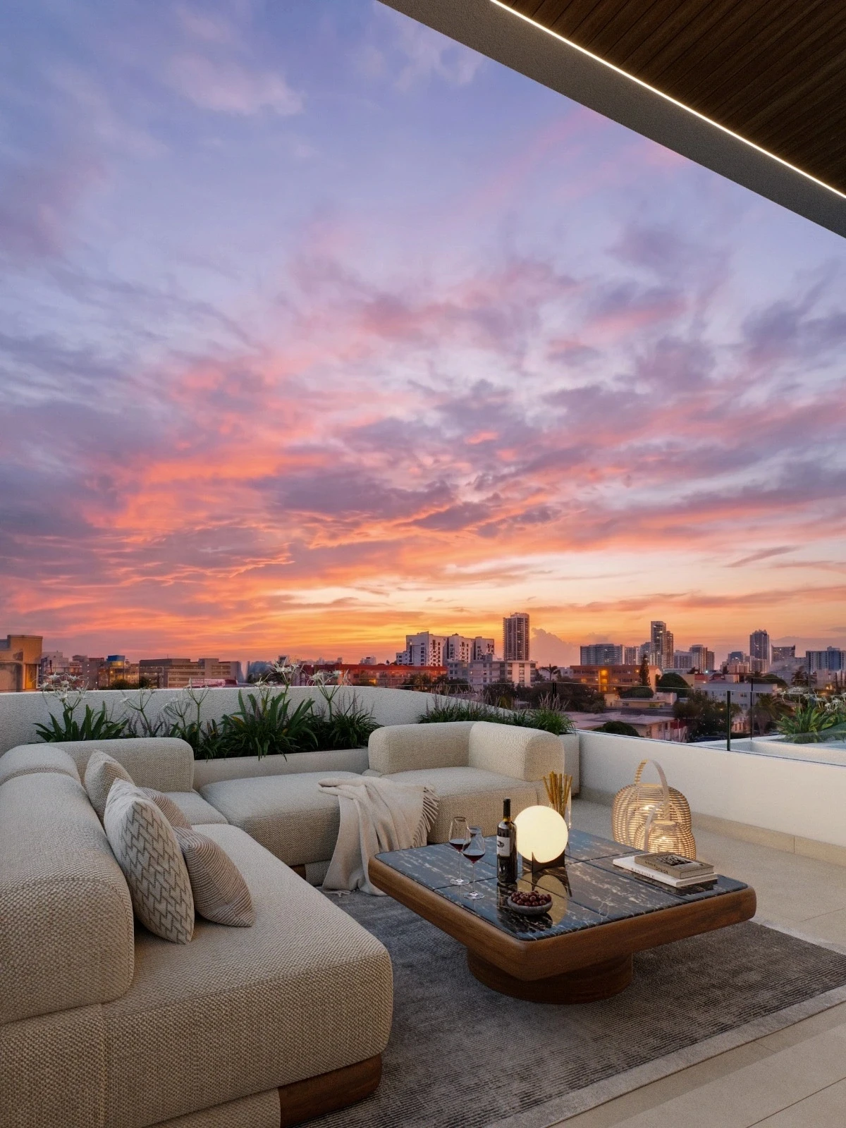 Covered balcony lounge at Byron Avenue Residence in North Beach, Miami Beach, with lit wood soffit, glass railing and sunset skyline views