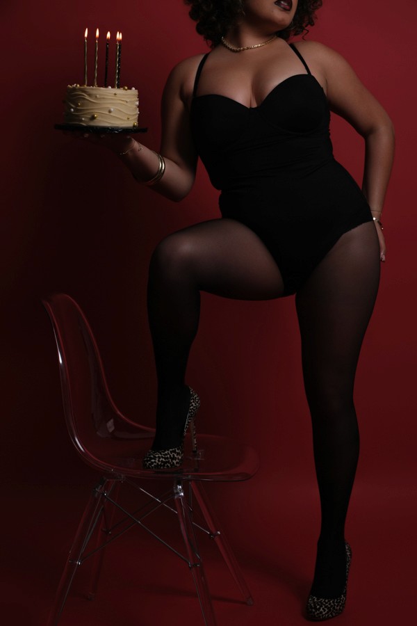 Moody fashion portrait in a black bodysuit under red light