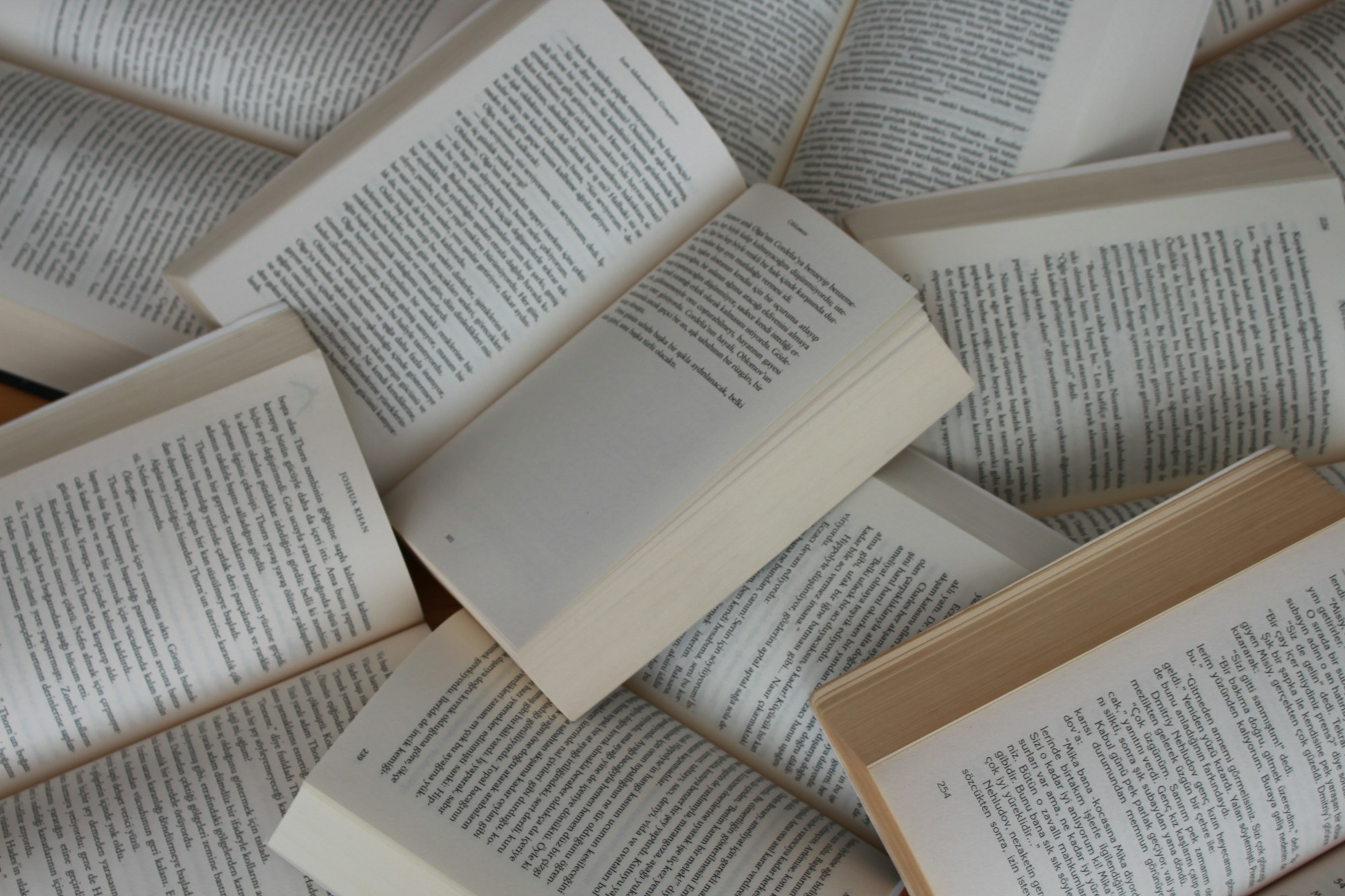 Open books arranged together on a light surface