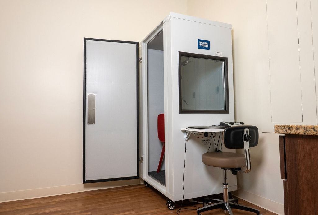 Member completing a hearing screening at Harper Health as part of personalized medical care.