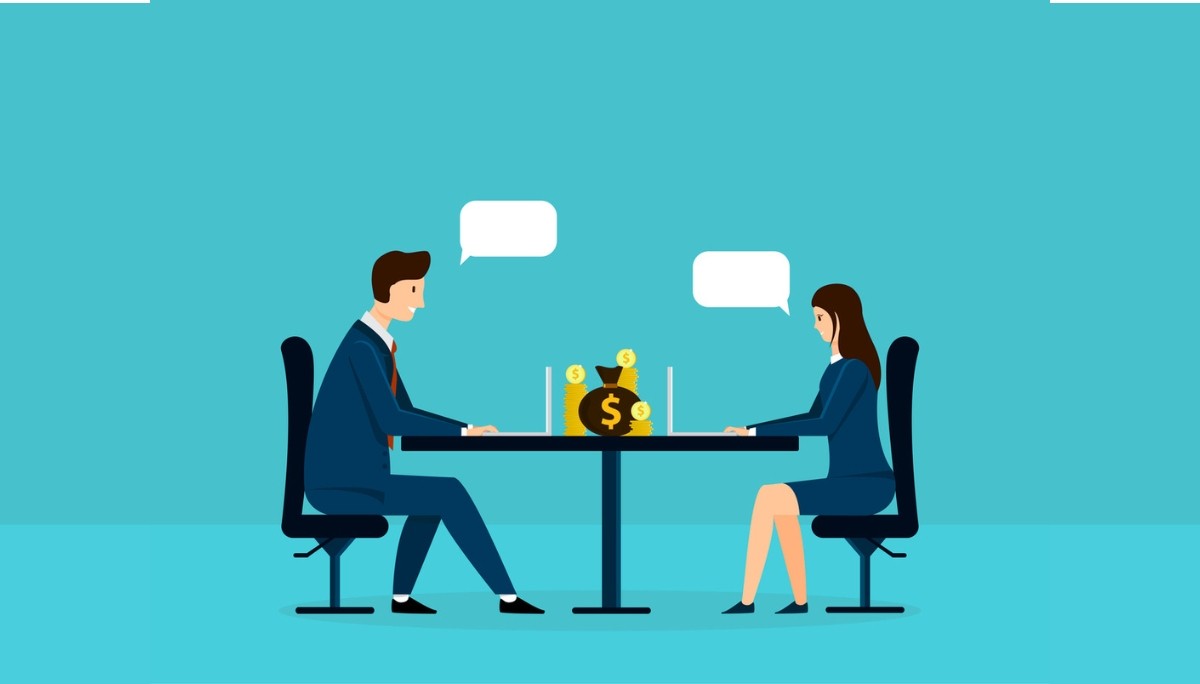Illustration of two professionals seated at a desk with laptops, discussing a large money bag and stacks of coins—symbolizing salary negotiation strategies, financial conversations, and the tactics that lead to better compensation.