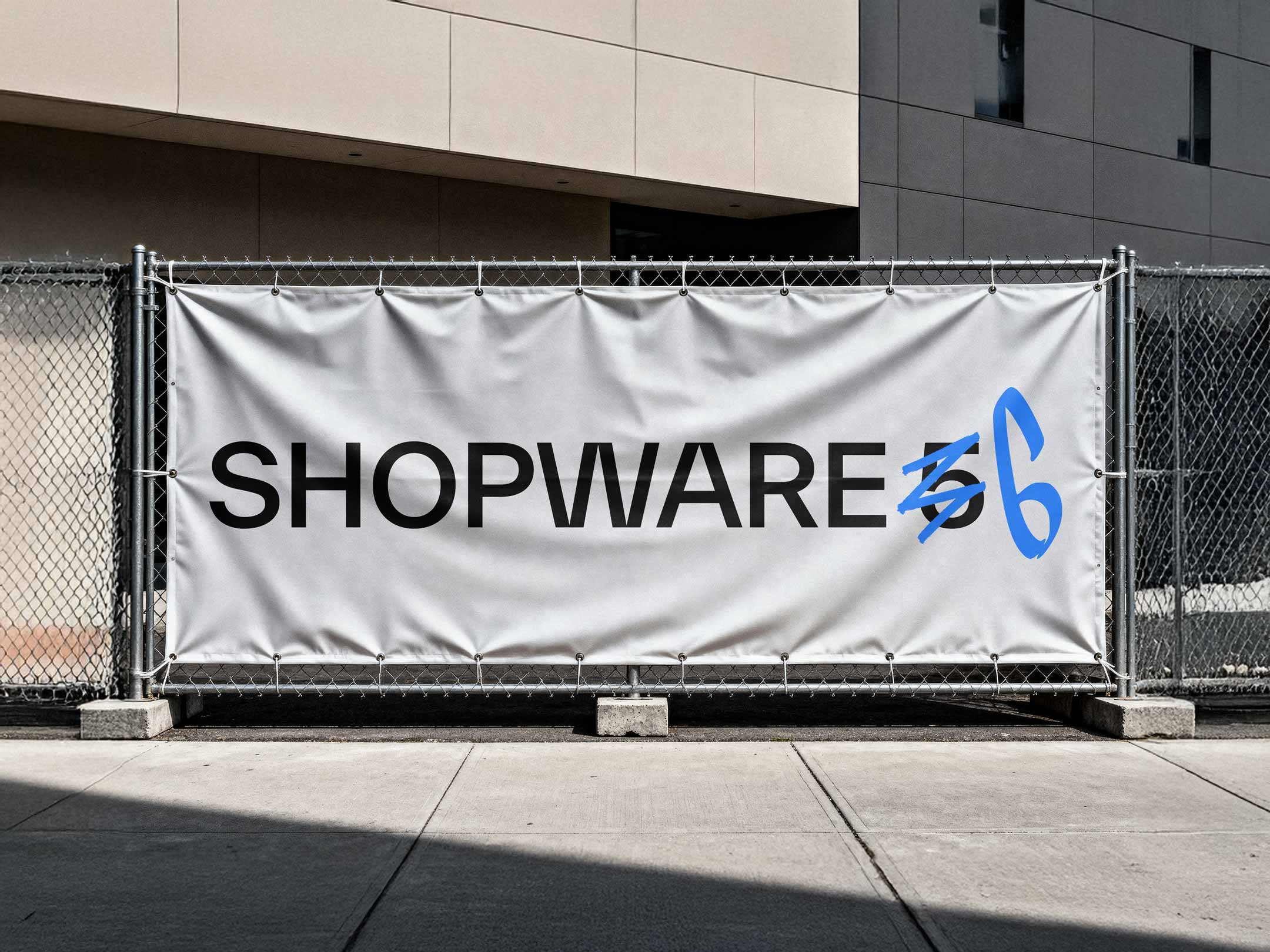 Ein Bauzaun, auf dem ein Werbeplakat hängt. Auf ihm steht "Shopware 5 zu 6"