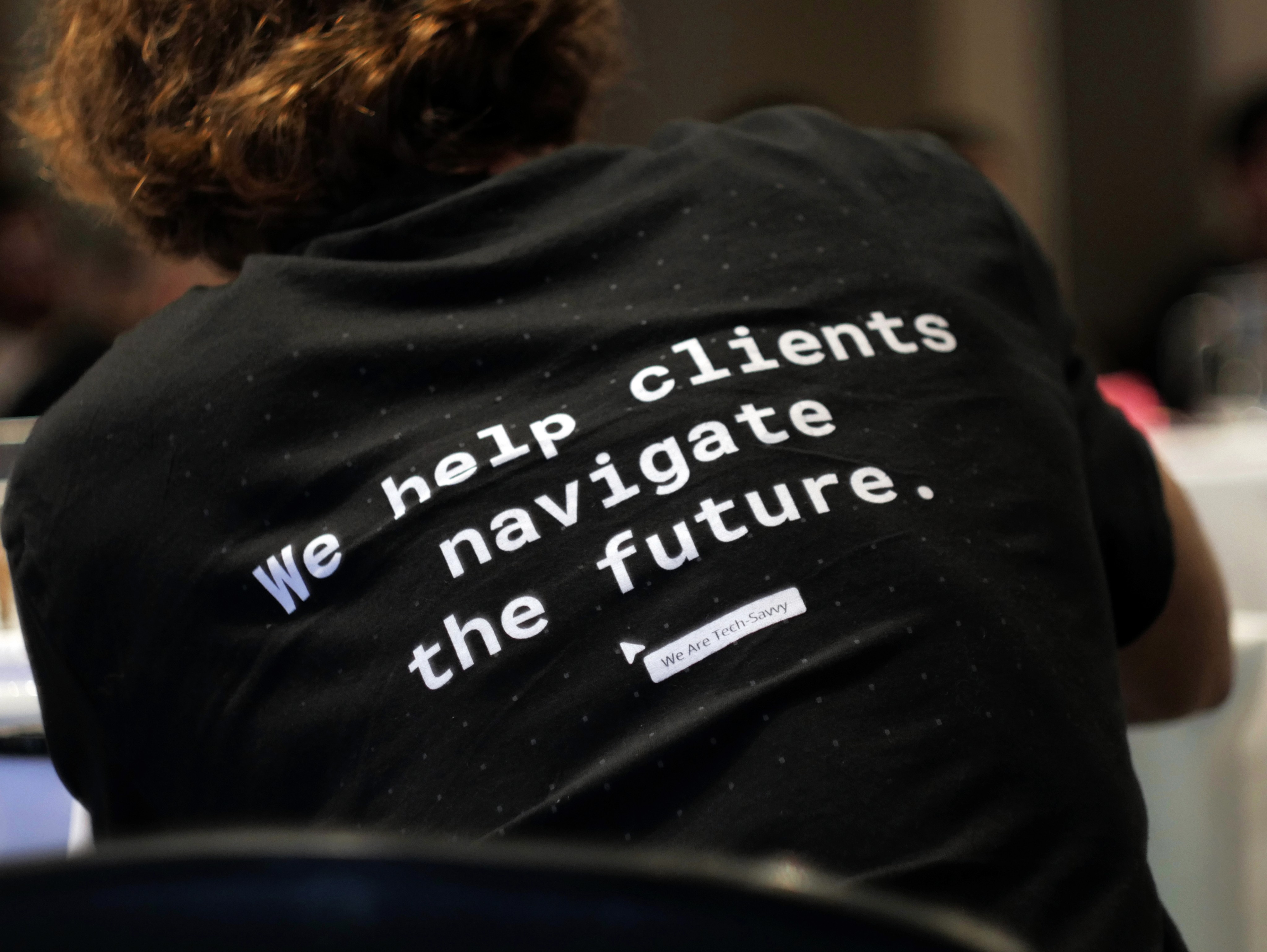 Close-up of a SpaceDev shirt featuring the company motto: "We help clients navigate the future."