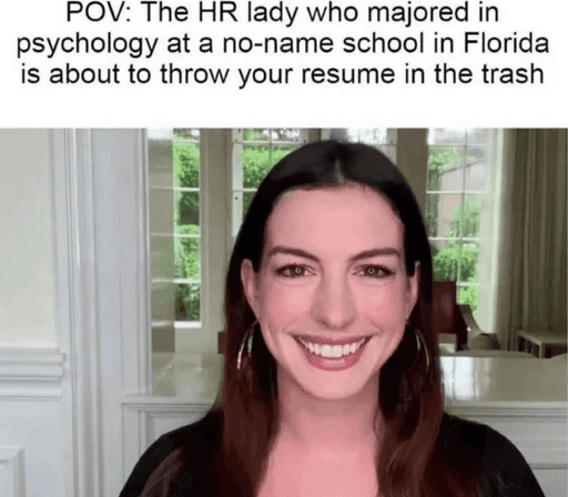 An image of Anne Hathaway giving an apparently-forced smile, captioned "POV: the HR lady who majored in psychology at a no-name school in Florida is about to throw your resume in the trash.