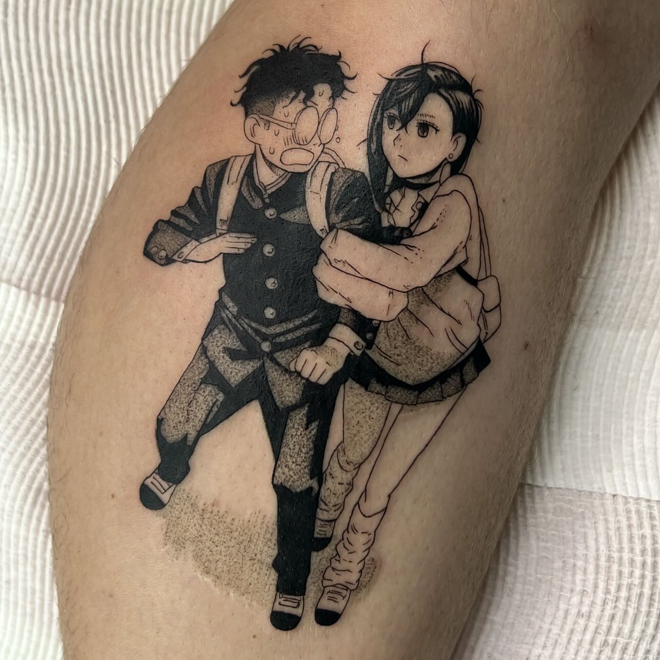 This tattoo of Momo and Okarun showcases their inseparable bond with a cinematic composition. The black and grey tones highlight their expressions—Okarun's comical shock and Momo's protective determination. The fine linework and soft shading create a manga-esque aesthetic that feels as if it’s been lifted straight from the panels of Dandadan. It's a heartfelt piece for fans who adore their dynamic.