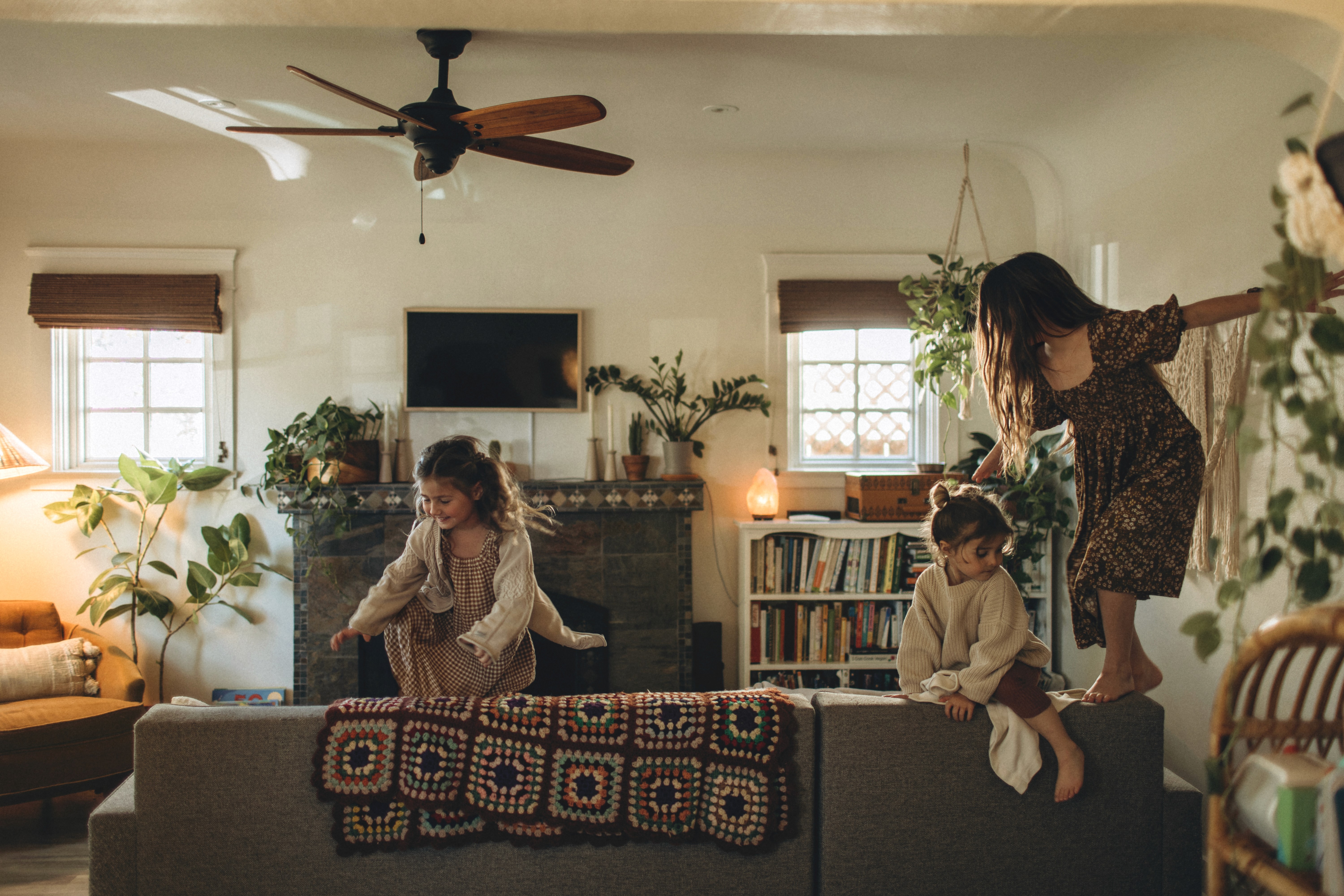 Kids playing freely in a cozy living room during an in-home family photo session in San Diego.
