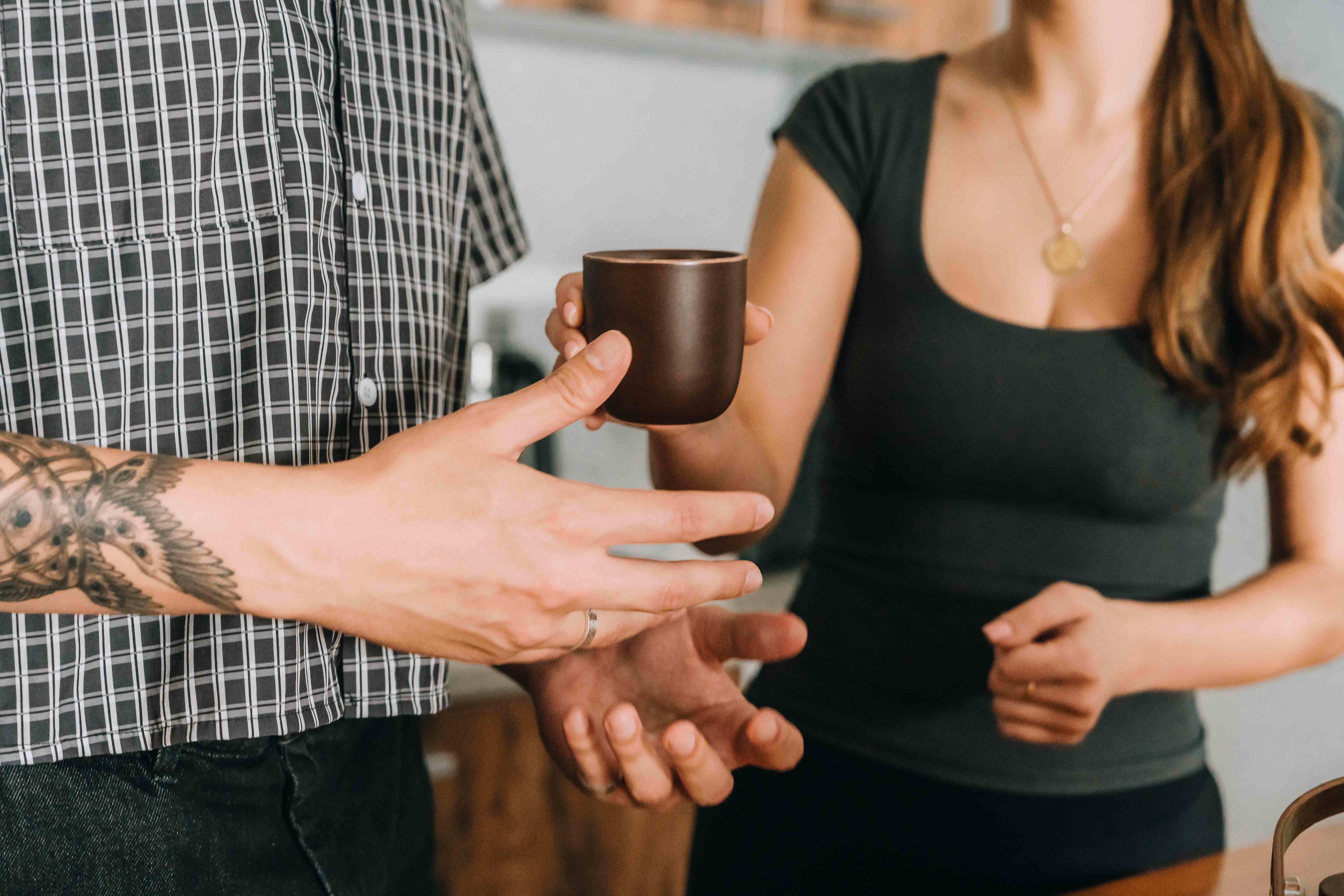 woman in black and white checkered long sleeve shirt sitting beside man in green crew neck