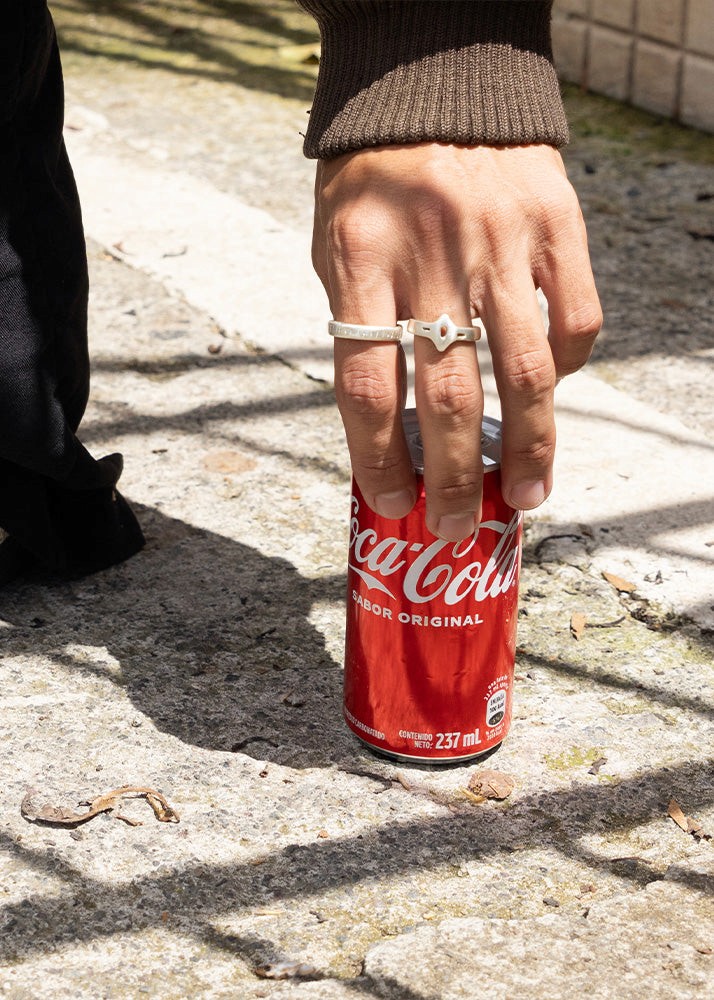 Men with a coca cola can, wearing silver rings