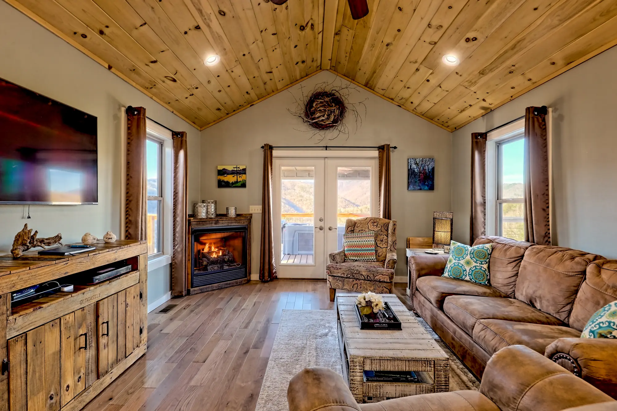 Eagles Nest living room with a gas fireplace, wall TV and French doors to the deck