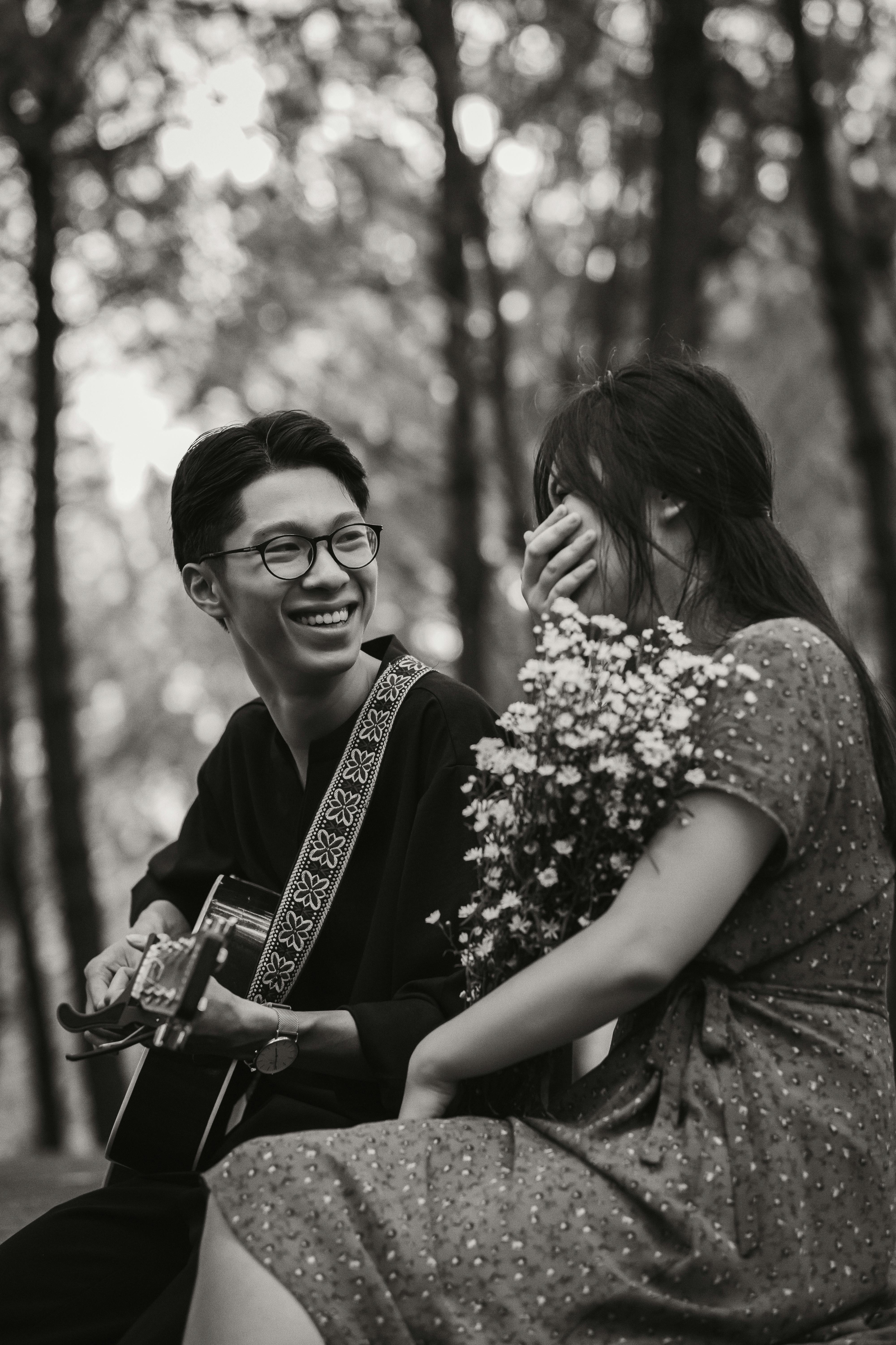A joyful couple stands back-to-back outdoors.