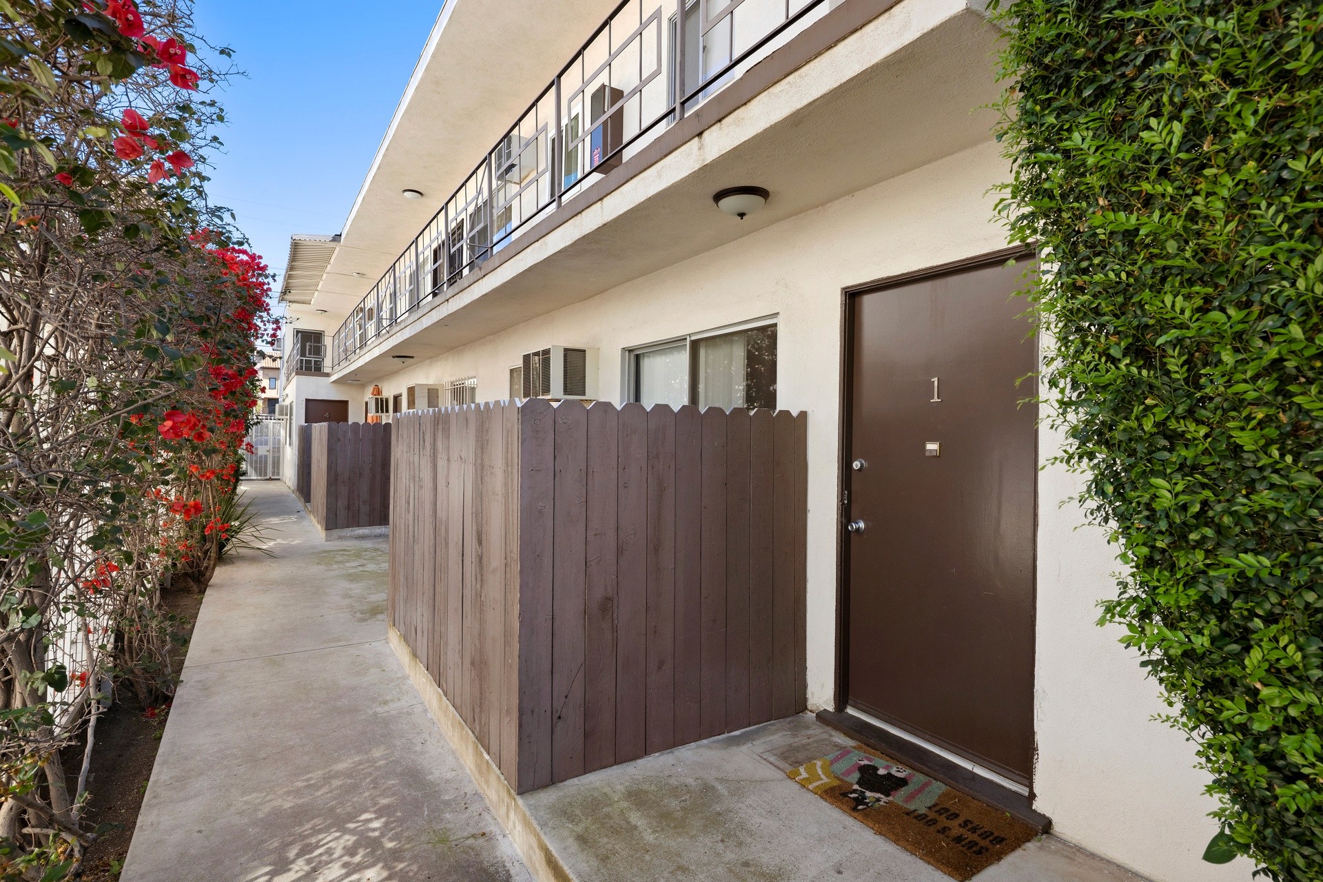 Ground-floor unit walkway at 1336 n citrus ave with private patio fencing.