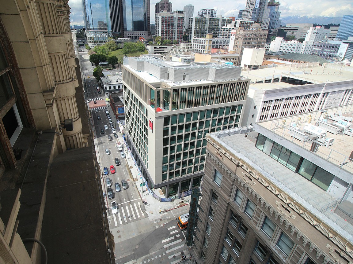 Aerial view of the completed hotel, featuring a small outdoor fitness terrace prominently visible on the 10th floor.