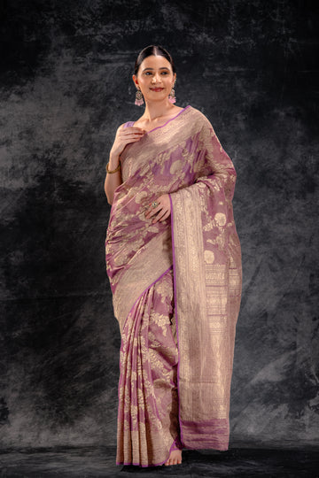 A woman wearing a peach tissue saree with a golden border from That Saree Shop, radiating a soft sheen and luxurious texture that captures timeless elegance and traditional charm.