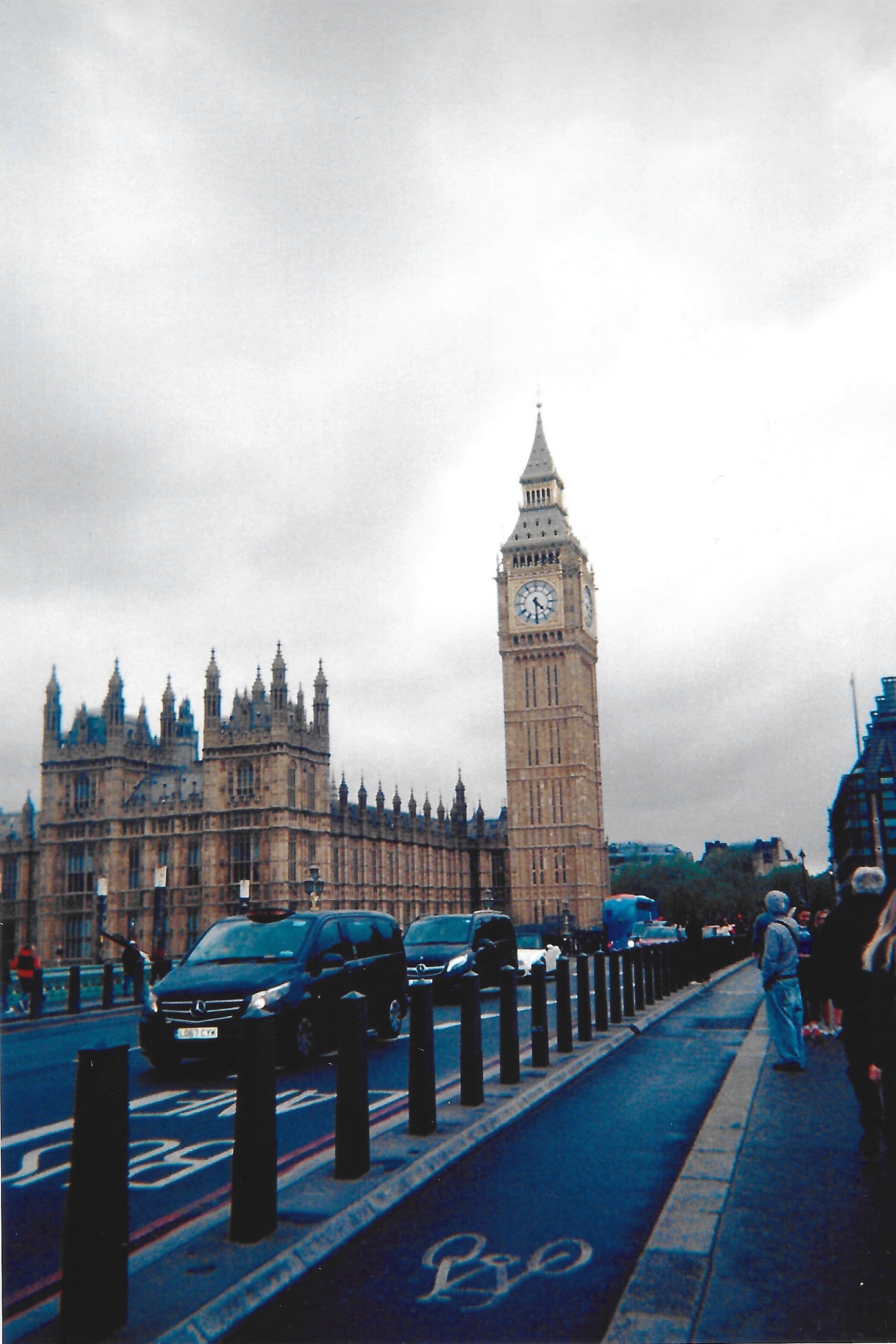 A close-up of a hand wearing multiple decorative rings against a blue background.