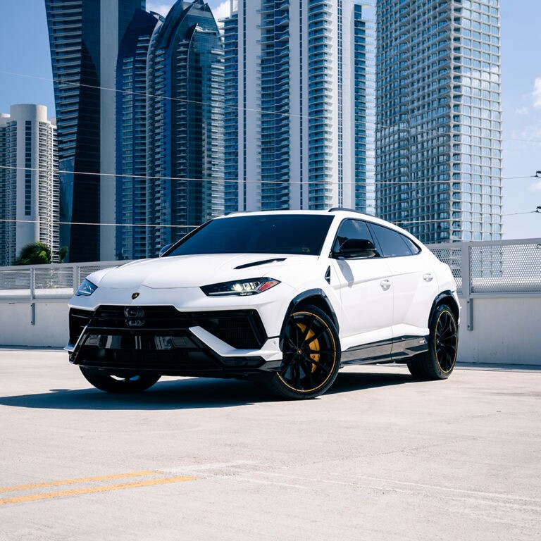 Side profile of white Lamborghini Urus S, black wheels, performance SUV rental.